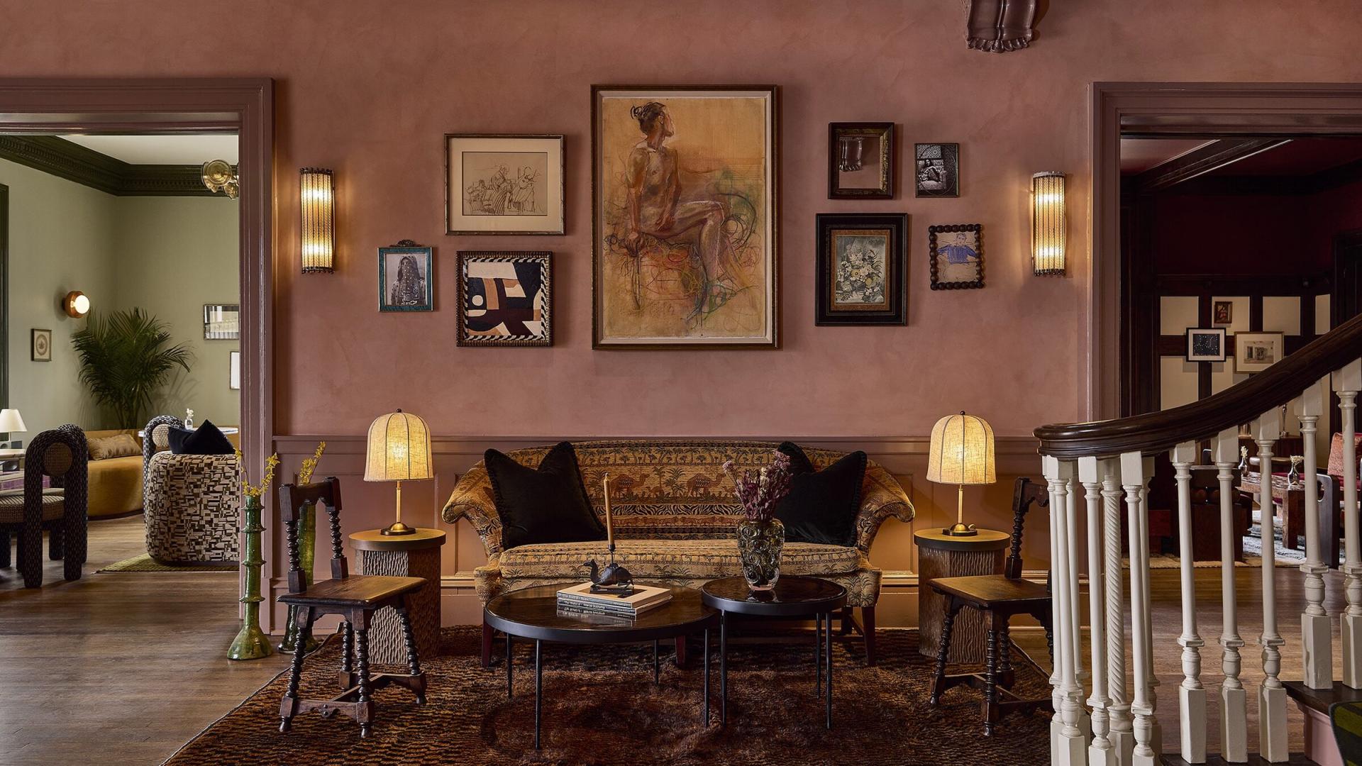 The lobby of The Camel Club in Lexington, with pink plaster walls, framed art and a staircase